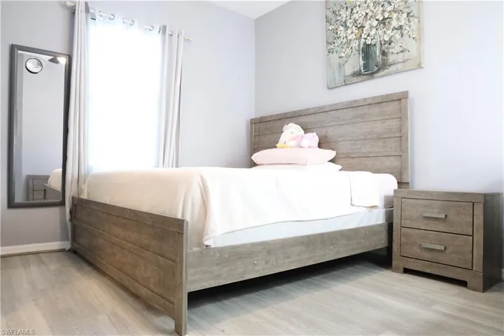 Bedroom with light wood-style vinyl flooring