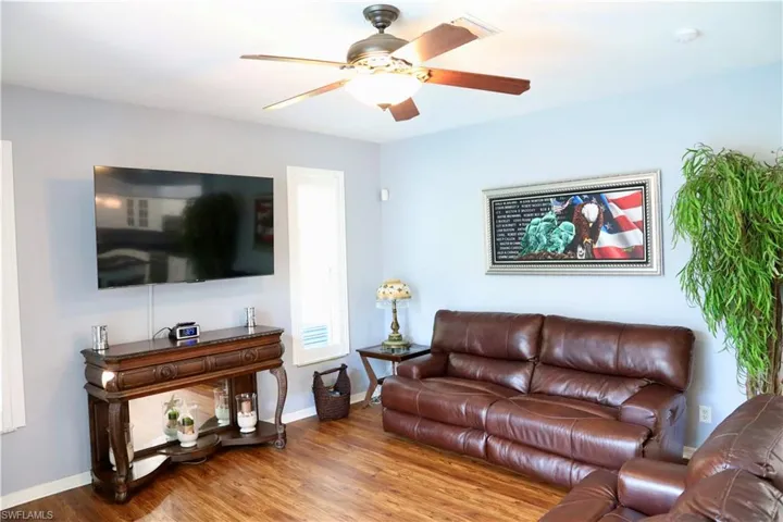 Living room with wood-type vinyl flooring and ceiling fan