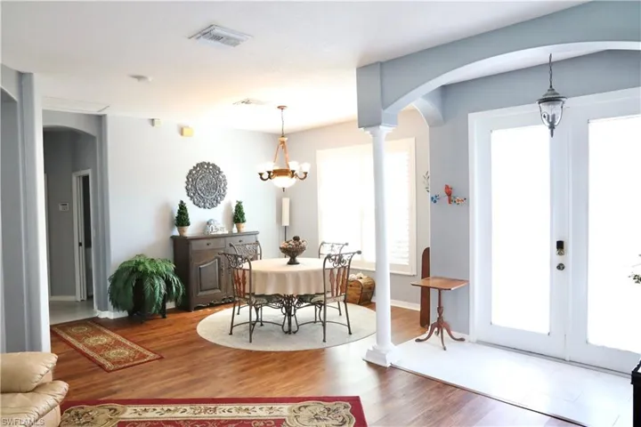 Dining space featuring hardwood / wood-style floors, french doors, and a chandelier