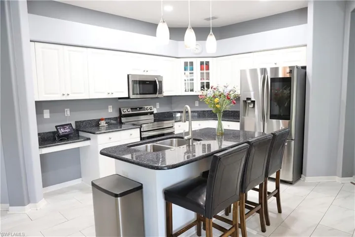 Kitchen featuring white cabinetry, a kitchen island with sink, and appliances with stainless steel finishes