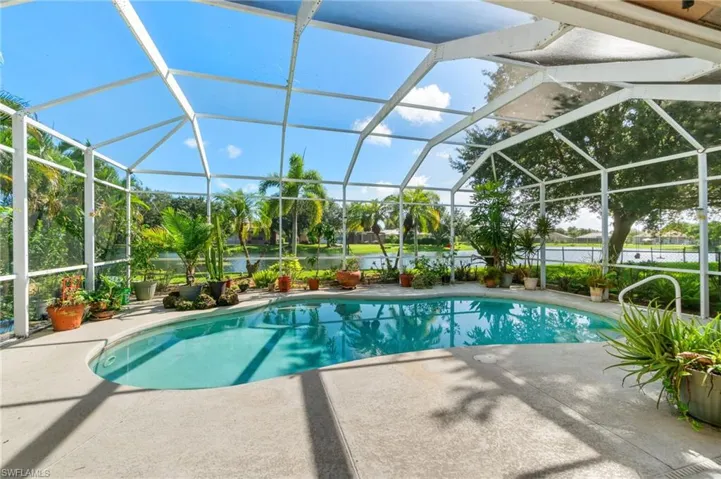 View of pool featuring a patio and glass enclosure