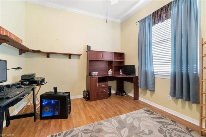 Office with light hardwood / wood-style floors, ornamental molding, and plenty of natural light