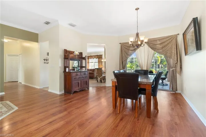 Dining room featuring an inviting chandelier, wood-type flooring, and ornamental molding