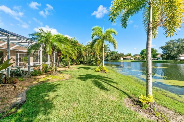 View of yard featuring a water view and glass enclosure