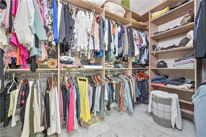 Walk in closet with light tile patterned floors