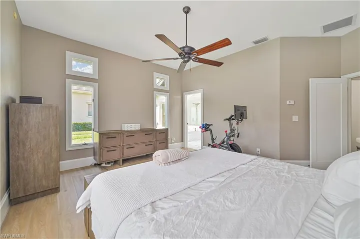 Bedroom with ceiling fan, light hardwood / wood-style floors, and ensuite bathroom