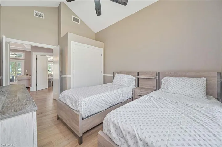 Bedroom featuring ceiling fan, high vaulted ceiling, and light hardwood / wood-style floors
