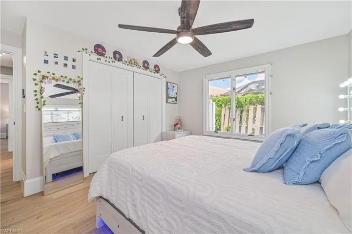 Bedroom with ceiling fan, light hardwood / wood-style flooring, and a closet