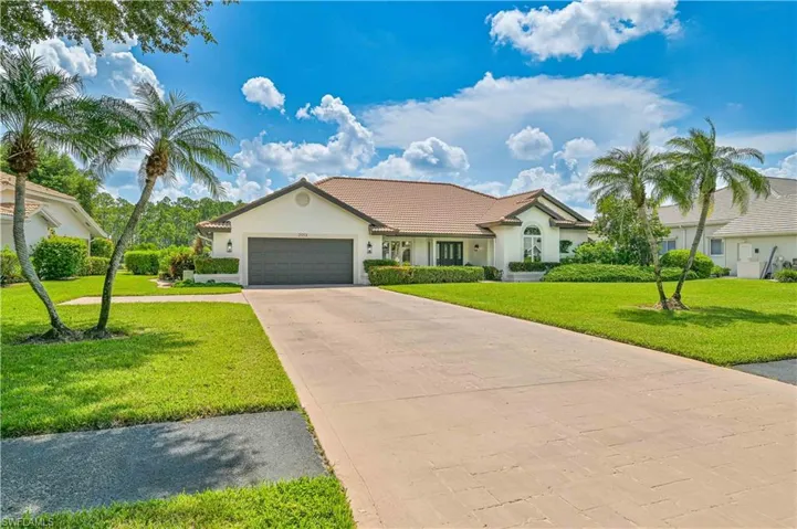 View of front of house with a garage and a front yard