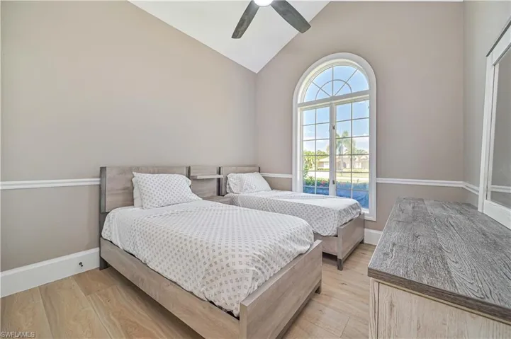 Bedroom with ceiling fan, high vaulted ceiling, and light hardwood / wood-style flooring