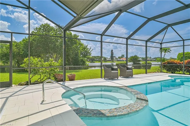 View of swimming pool with an in ground hot tub, a patio area, and a lanai