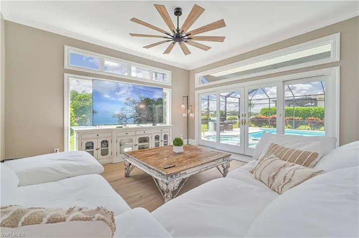 Living room featuring ceiling fan, light hardwood / wood-style floors, ornamental molding, and french doors