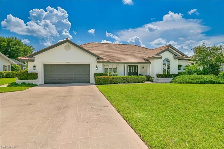 View of front of home with a front yard and a garage