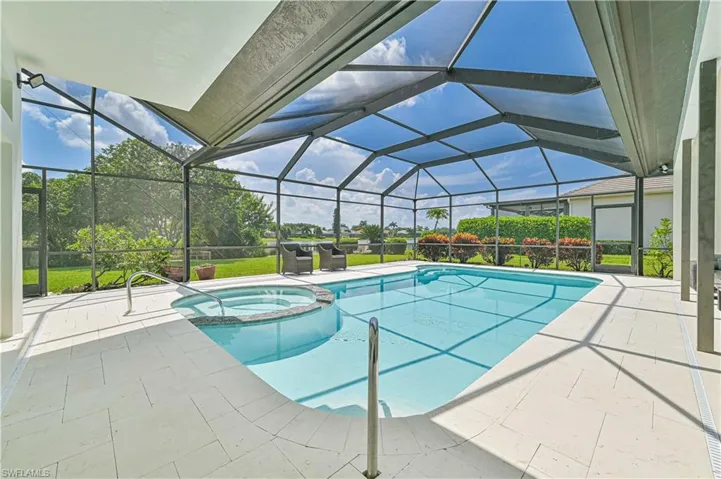 View of swimming pool featuring glass enclosure, an in ground hot tub, and a patio