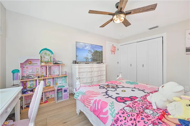 Bedroom featuring light hardwood / wood-style flooring, ceiling fan, and a closet