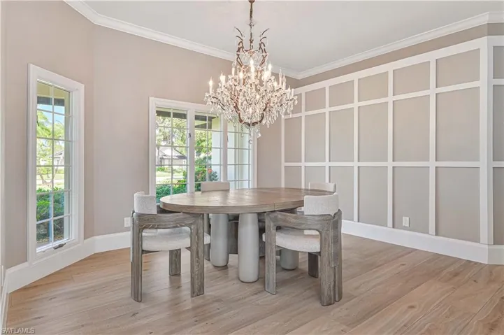 Dining space featuring hardwood / wood-style floors, an inviting chandelier, and ornamental molding