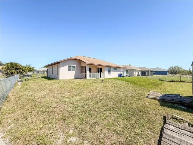 Back of property with a yard, a fenced backyard, and stucco siding