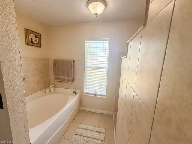Bathroom featuring tile patterned floors and a garden tub