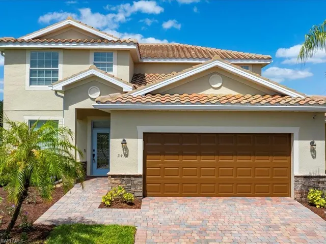 Newly painted home with brick paver driveway