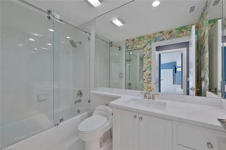 Full bathroom with vanity, toilet, and enclosed tub / shower combo