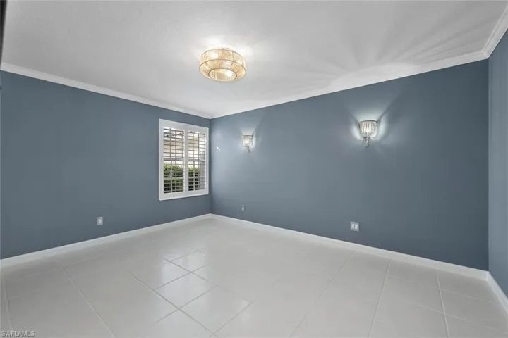 Spare room with crown molding, light tile patterned floors, and a textured ceiling
