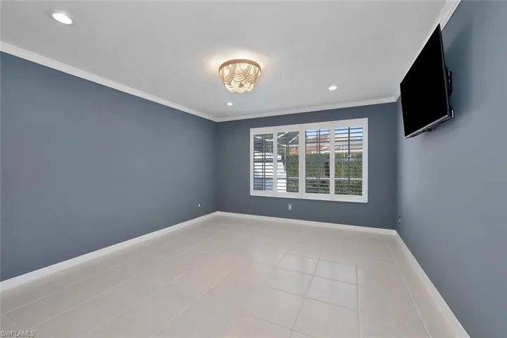 Tiled empty room featuring ornamental molding