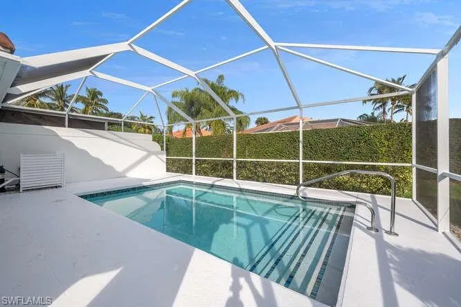 View of swimming pool featuring a patio and glass enclosure