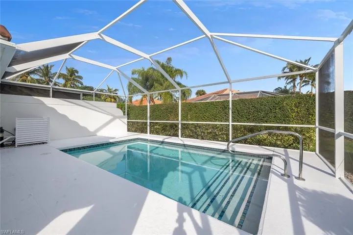 View of swimming pool featuring a patio area and glass enclosure