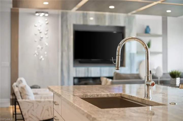 Kitchen view of light stone countertops and recessed lighting