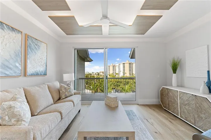 Living area featuring wood finished floors, ceiling fan, and coffered ceiling