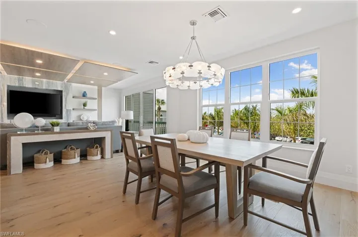 Dining space featuring light wood finished floors, recessed lighting, built in features, and a chandelier