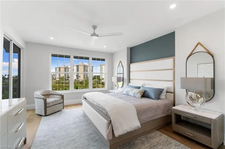 Bedroom with light wood finished floors, ceiling fan, and recessed lighting