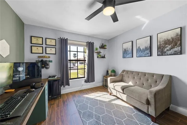 Living room featuring dark hardwood / wood-style flooring and ceiling fan