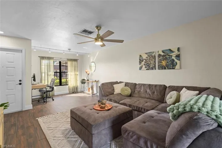 Living room with rail lighting, a textured ceiling, dark hardwood / wood-style floors, and ceiling fan