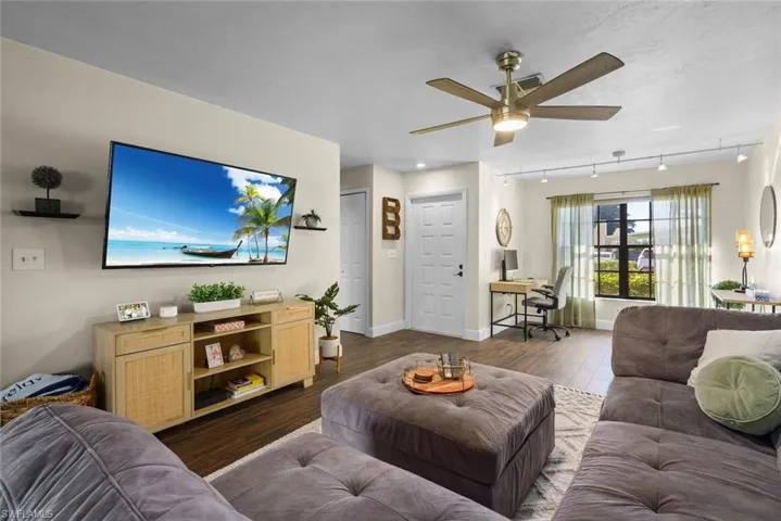 Living room featuring track lighting, dark hardwood / wood-style floors, and ceiling fan