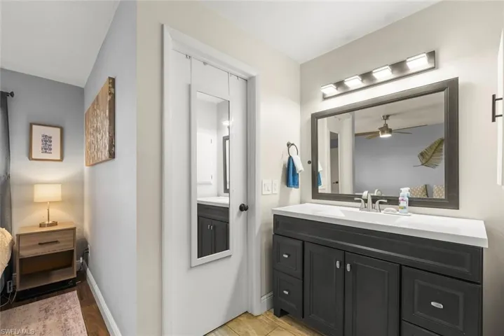 Bathroom with vanity, wood-type flooring, and ceiling fan