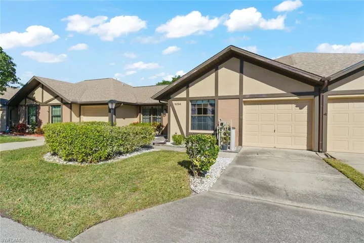 View of front of home with a garage and a front lawn