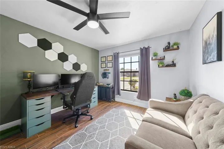 Home office featuring ceiling fan and dark hardwood / wood-style flooring