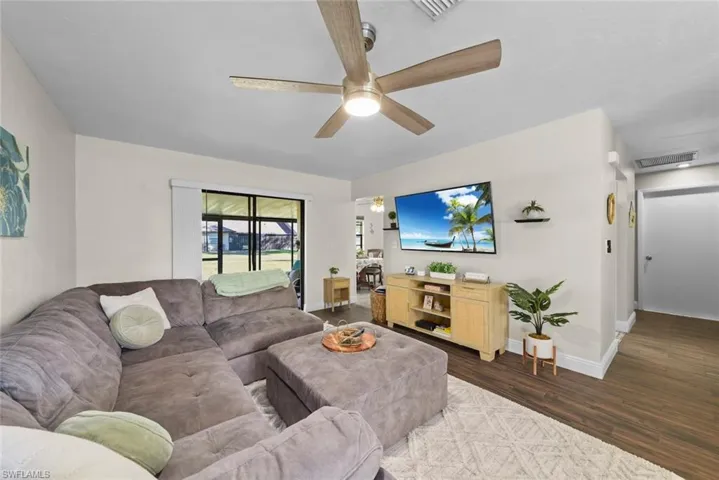 Living room with dark hardwood / wood-style floors and ceiling fan