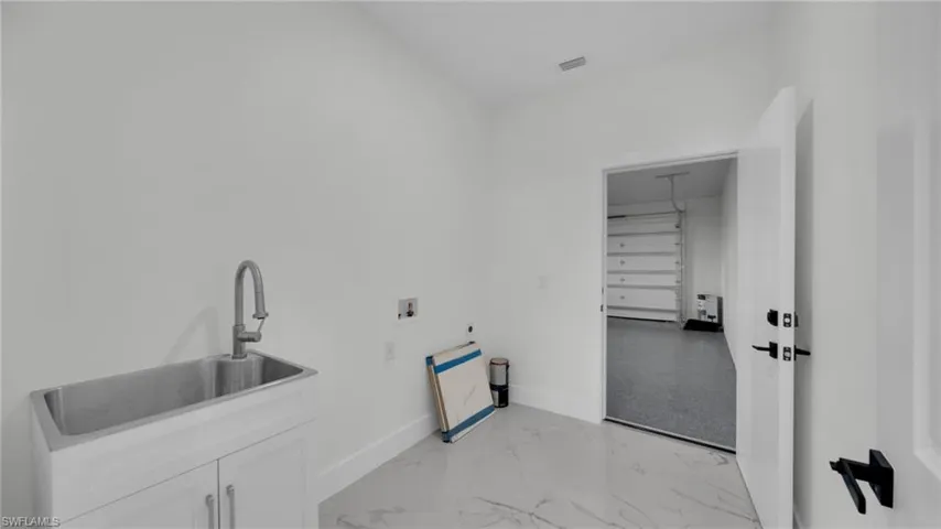 Laundry room with washer hookup and light marble finish floors