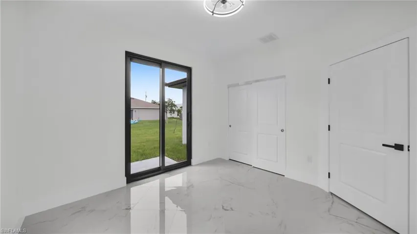 Unfurnished bedroom with light marble finish flooring and access to outside
