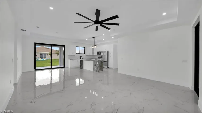 Unfurnished living room featuring recessed lighting, light marble finish floors, and a ceiling fan