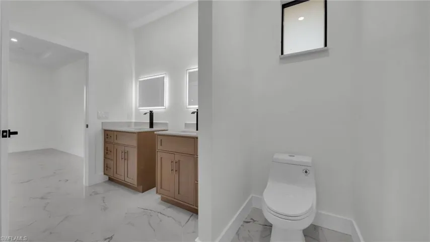 Bathroom featuring light marble finish floors, vanity, and recessed lighting