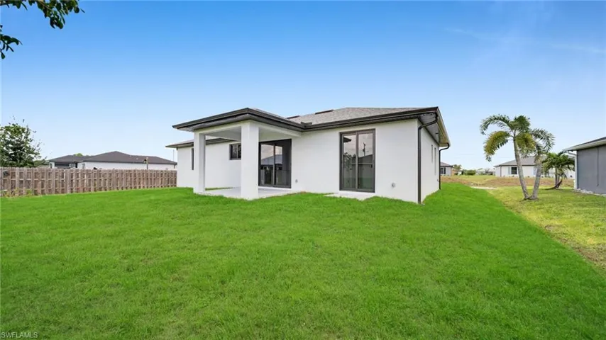 Back of house with stucco siding and a patio