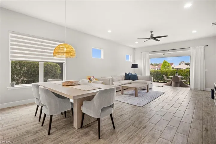 Dining room with wood tiled floors, ceiling fan, and recessed lighting