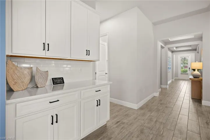 Corridor with baseboards and light wood finished tile floors