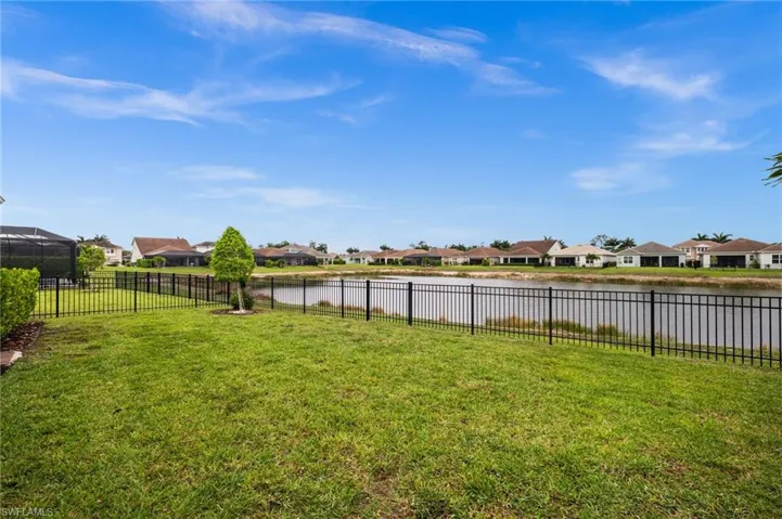 Fenced backyard featuring a water view