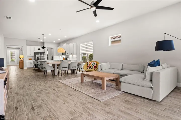 Living room featuring a ceiling fan, wood tiled floors, and recessed lighting