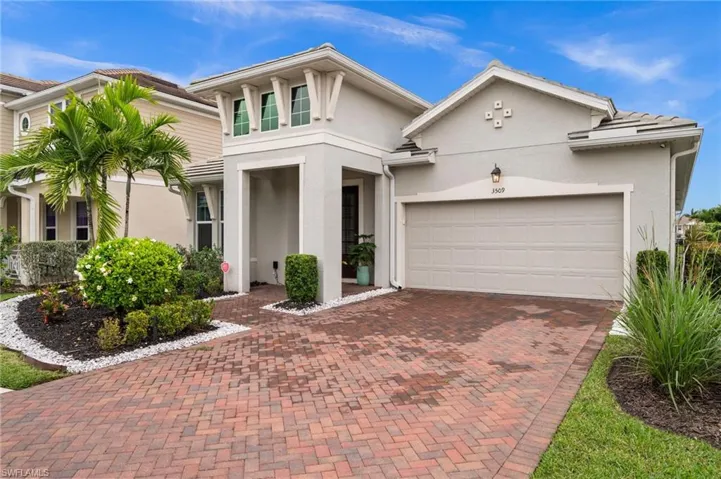 View of front of property with decorative driveway and stucco siding