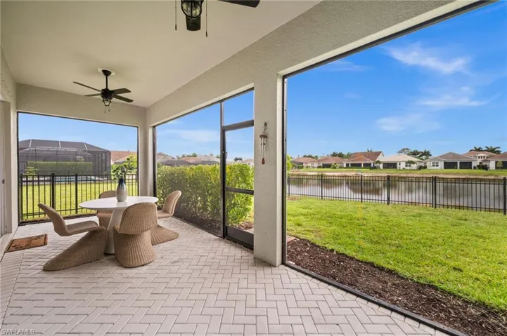 Sunroom / solarium with a residential view, ceiling fan, and outdoor dining area